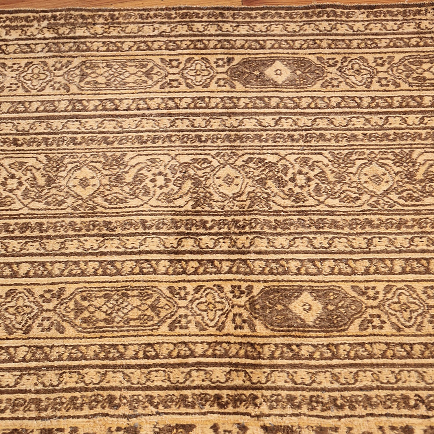 Close-up of intricate, aged Oriental rug showcasing traditional patterns and textures.