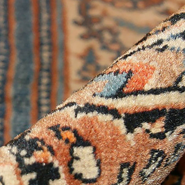 Close-up of a traditional patterned rug with intricate motifs.