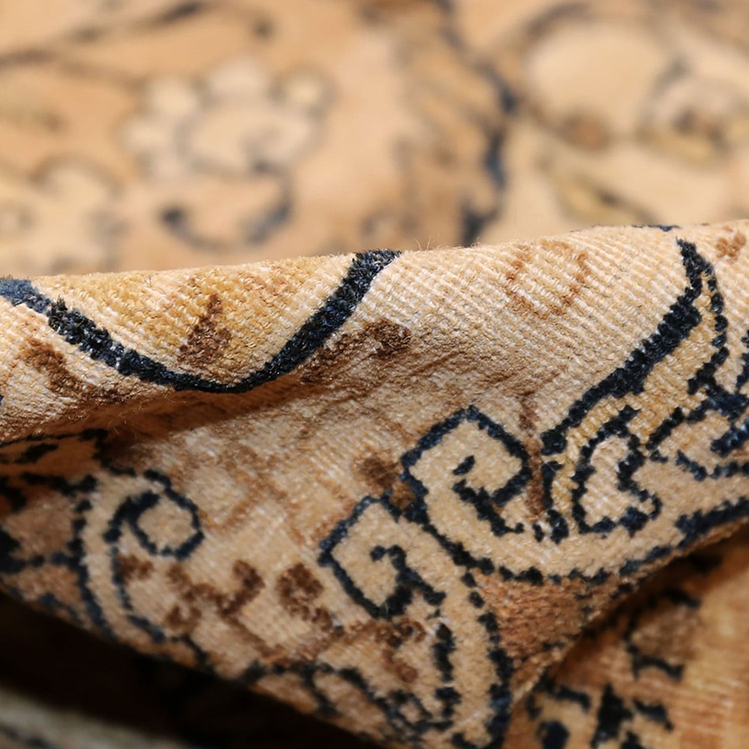 Close-up of a woven fabric with intricate navy blue designs.