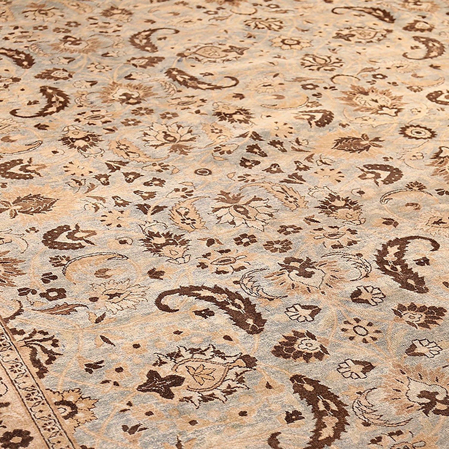 Close-up of a intricately designed woven rug in neutral tones.