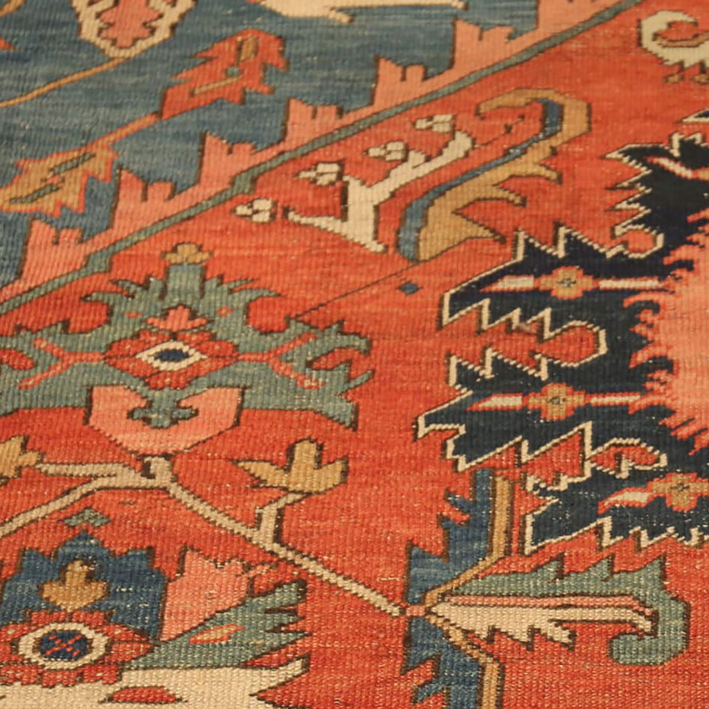 Intricate handwoven rug with vibrant red background and floral motifs.
