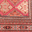 Close-up of a vibrant, handcrafted rug with intricate geometric patterns.