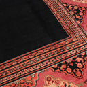 Intricately patterned traditional rug with dark central area and floral border.
