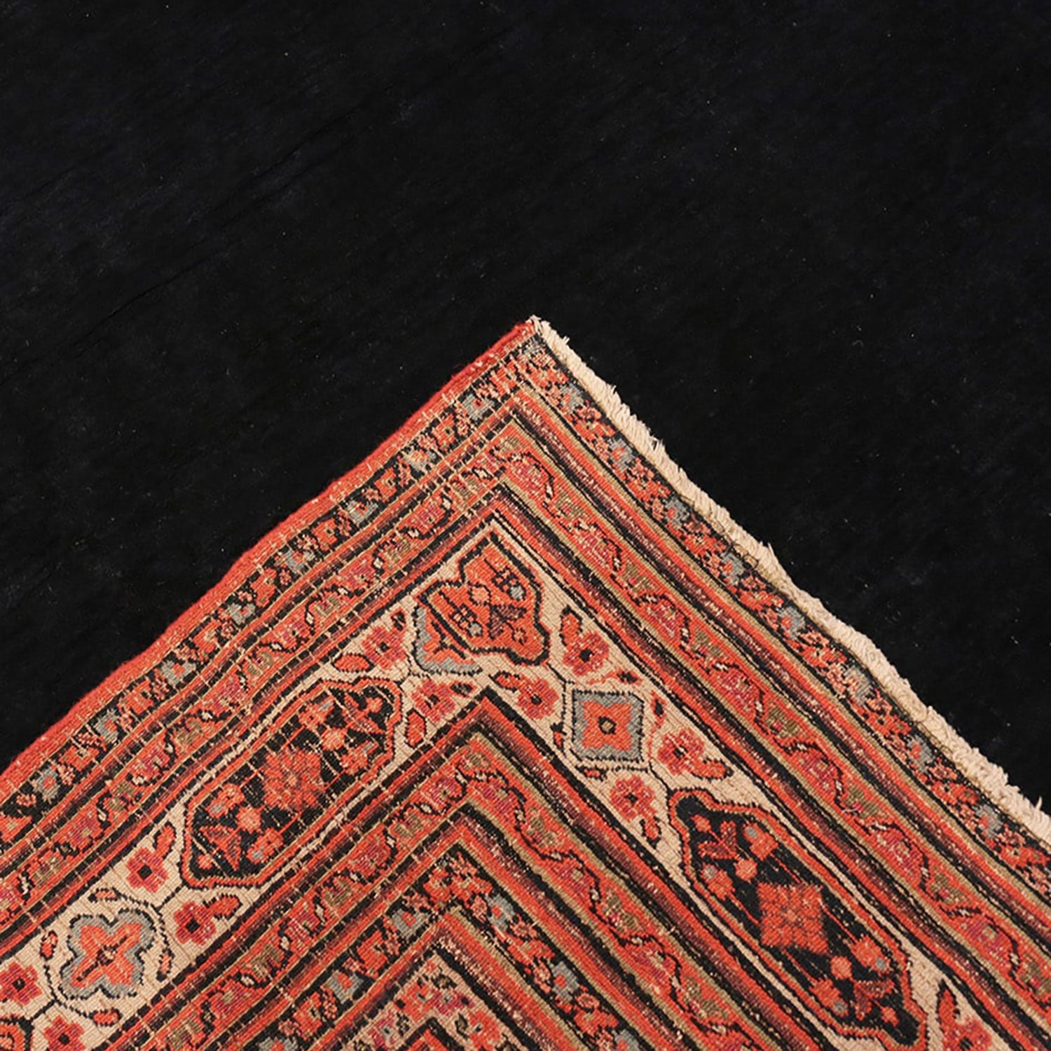 Close-up of a meticulously crafted Persian rug on dark flooring.