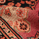 Close-up view of folded, ornate carpet showcases intricate patterns and rich colors.