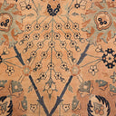 Close-up of intricate floral patterned carpet in beige and blue.