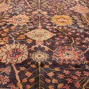 Close-up of a symmetrical, ornate patterned rug with vibrant colors.