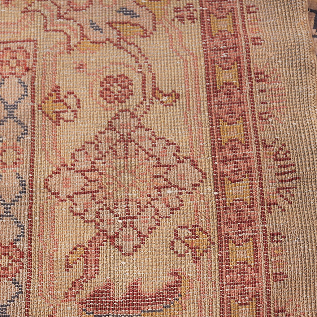 Close-up of a vintage handcrafted carpet with intricate floral patterns.