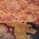 Close-up of rolled up carpet showcasing rich, warm colors and intricate texture.