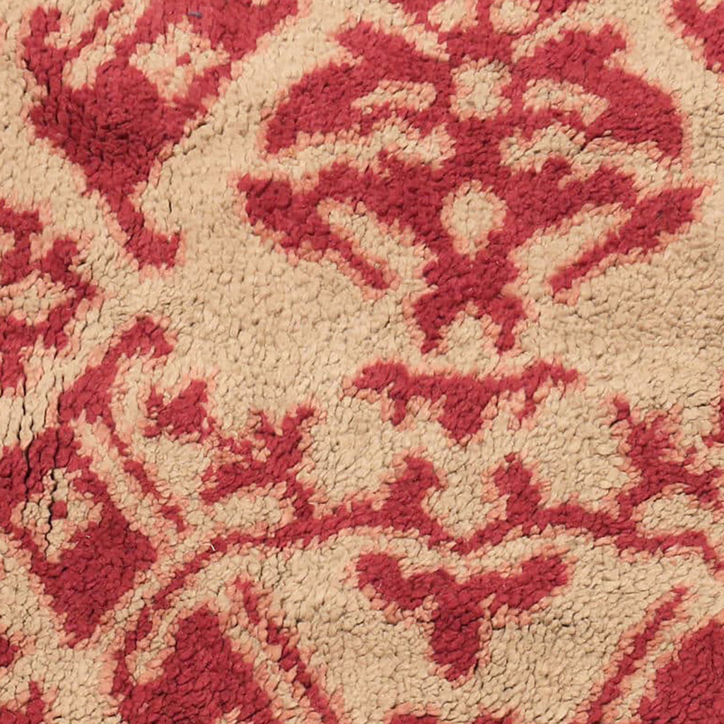 Intricate symmetrical design with red and beige elements on fabric.