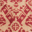 Close-up of a cream carpet with an intricate red design.