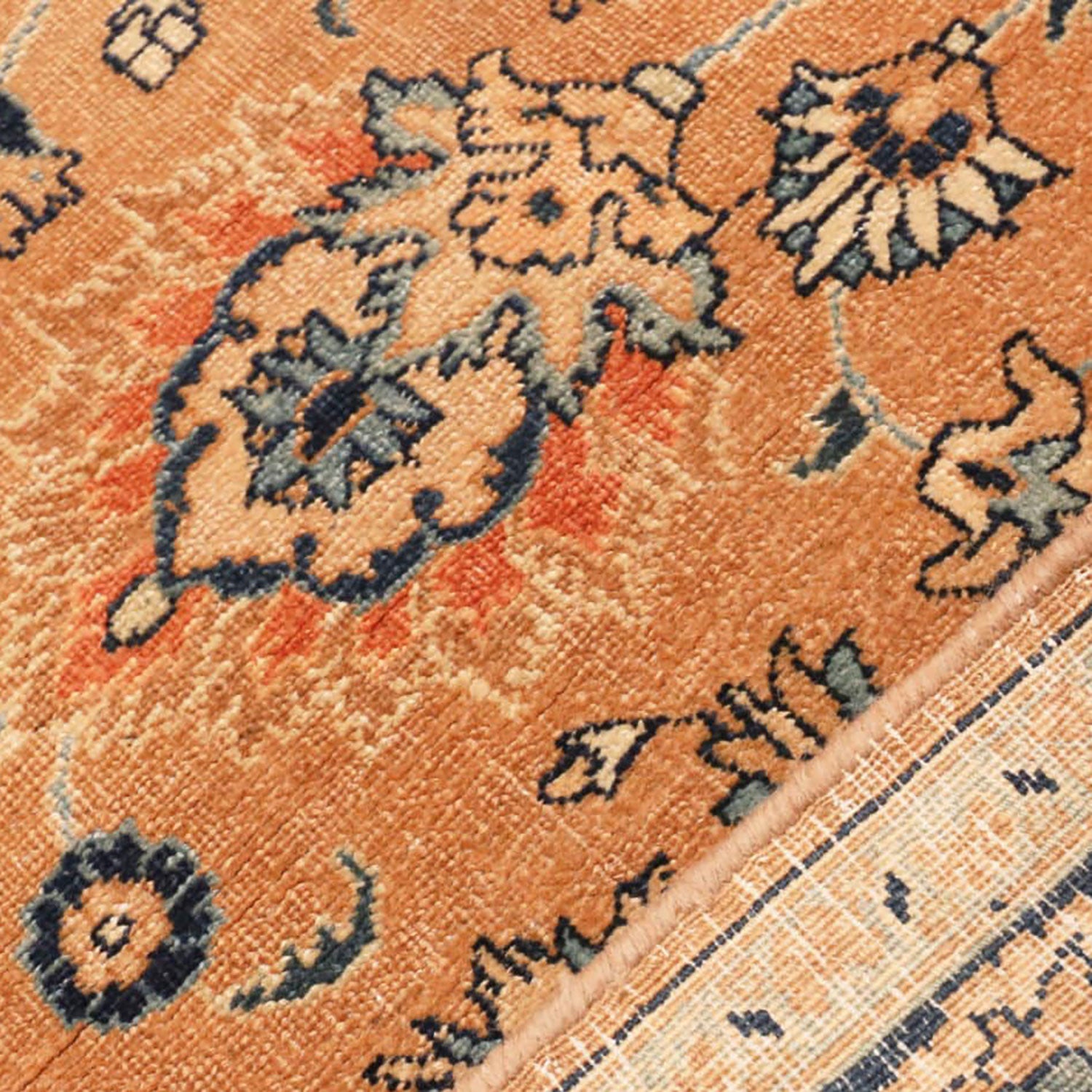 Close-up of an ornate vintage rug with traditional floral motifs.