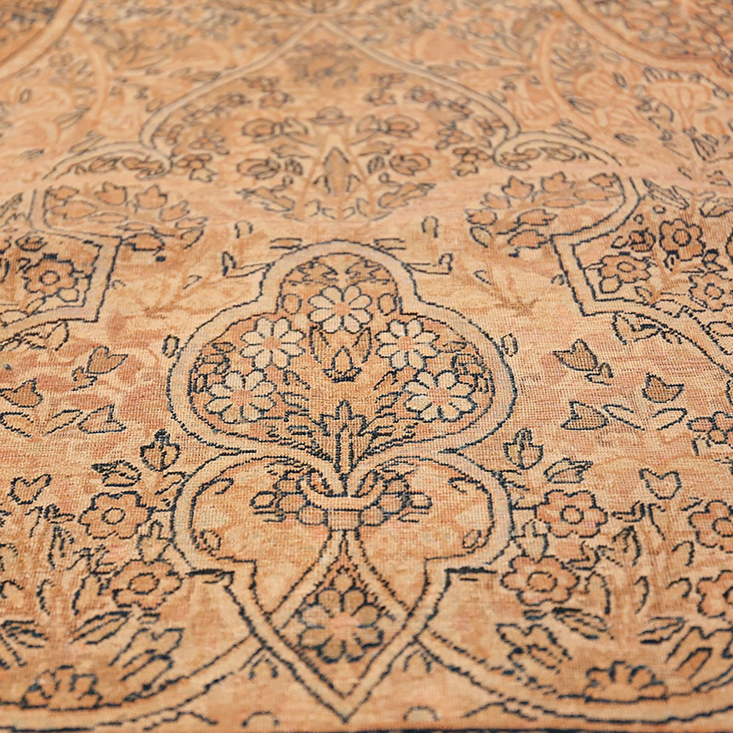 Close-up of an ornate, handwoven carpet with intricate floral motifs.
