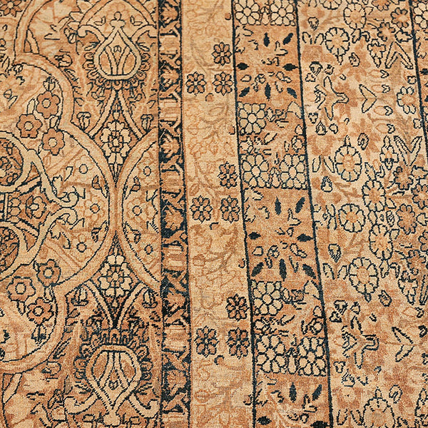 Close-up of an intricate patterned rug in warm earth tones.