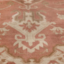 Elegant, symmetrical carpet with intricate pink and cream designs.