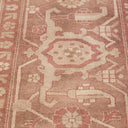 Close-up of a high-quality carpet with intricate geometrical and floral patterns in shades of pink.