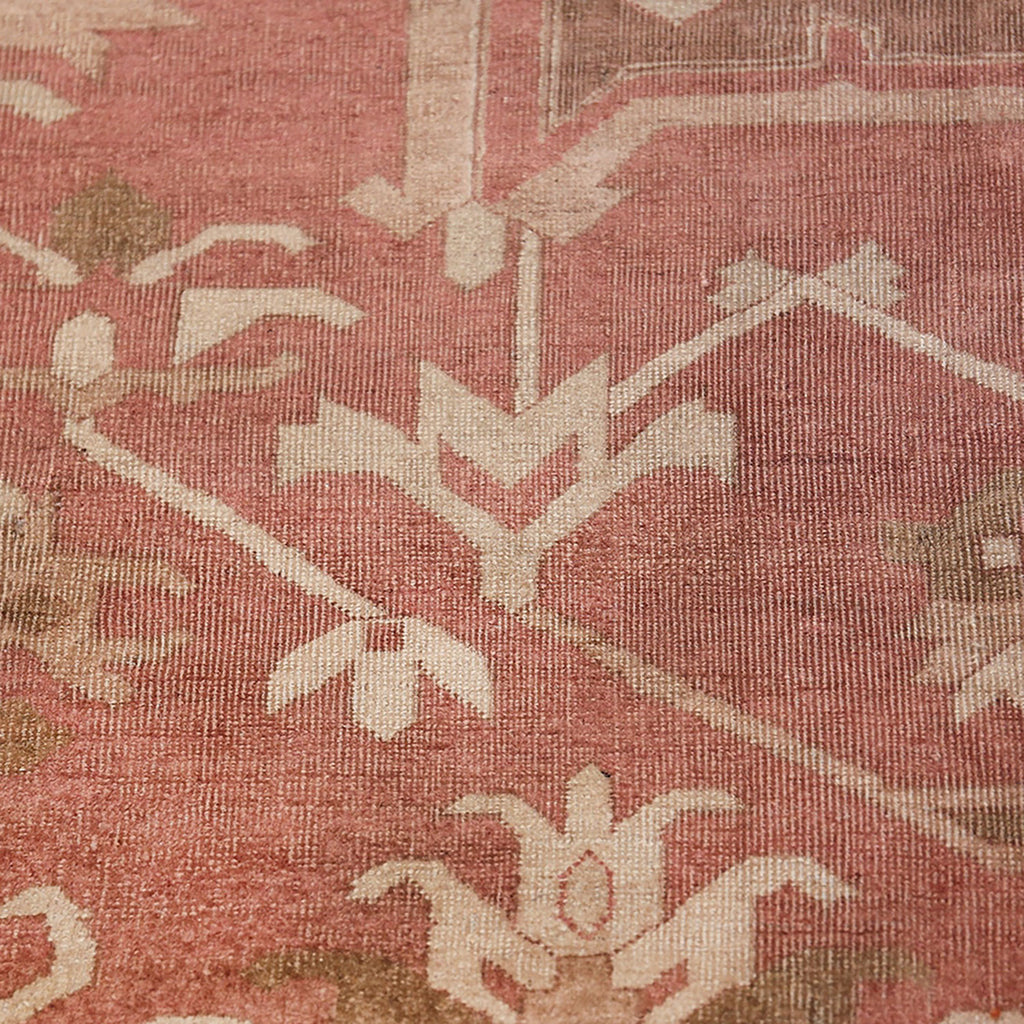Close-up of textured fabric with red tones and floral pattern.