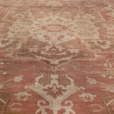 Symmetrical patterned carpet with floral and geometric motifs in muted tones.