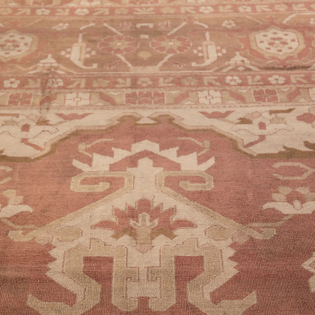 Intricate vintage rug featuring geometric and floral motifs in muted tones.