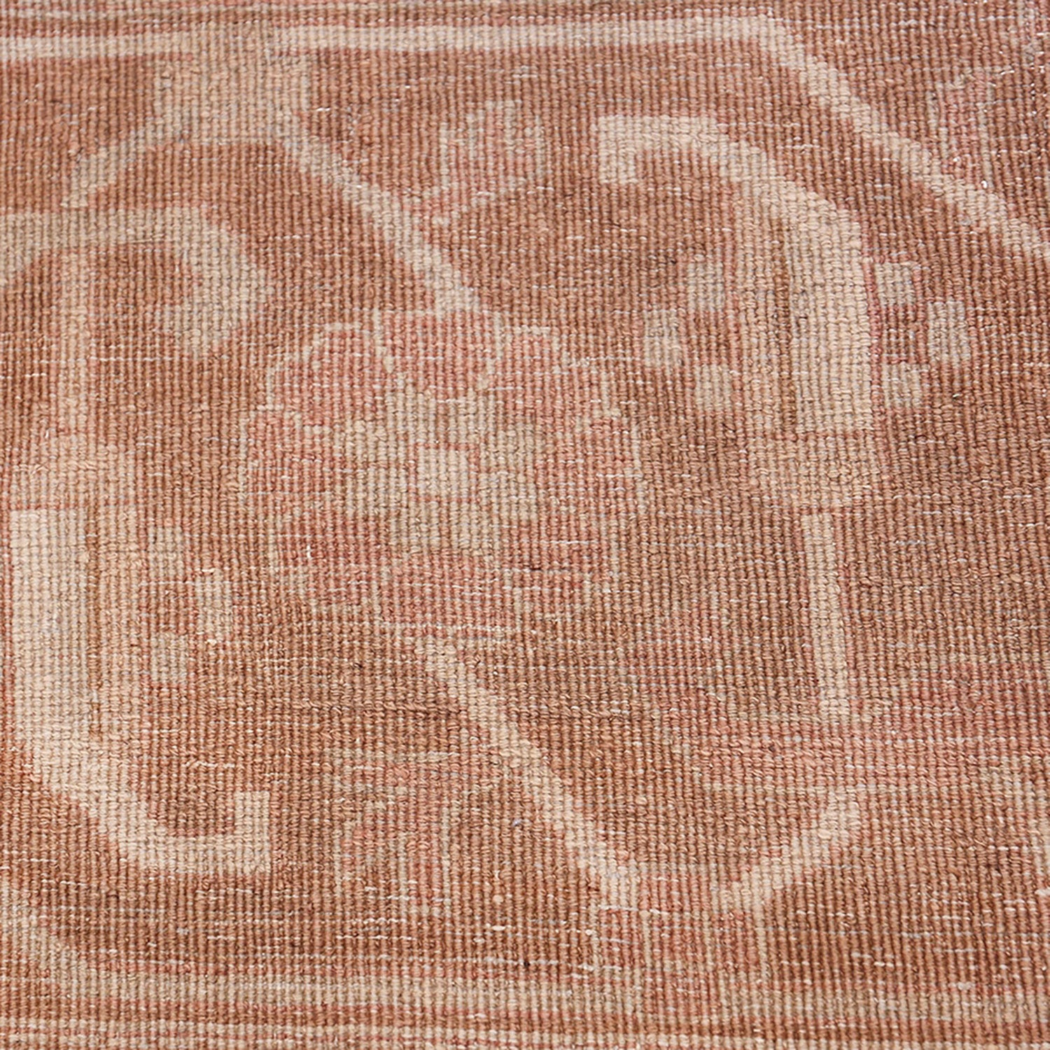 Close-up of a pink, tan, and white woven fabric pattern.