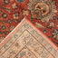 A close-up of two overlapping, intricately patterned rugs showcasing traditional craftsmanship.