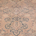 Vintage rug with ornate floral motifs showcases faded elegance.