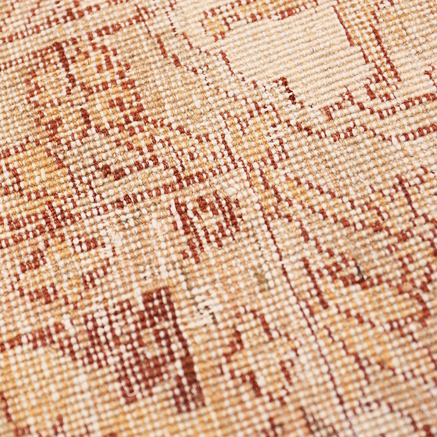 Close-up view of intricately woven fabric with warm-toned geometric design.