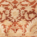 Intricately patterned carpet in warm tones with traditional motifs.