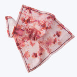 Vibrant pink and red tie-dye fabric with brown accents