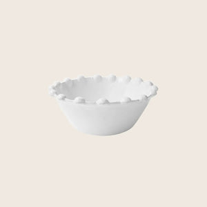White ceramic bowl with unique scalloped edge design on display.