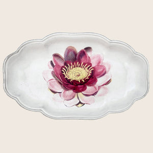Delicate ceramic dish with pink flower design and scalloped edge.