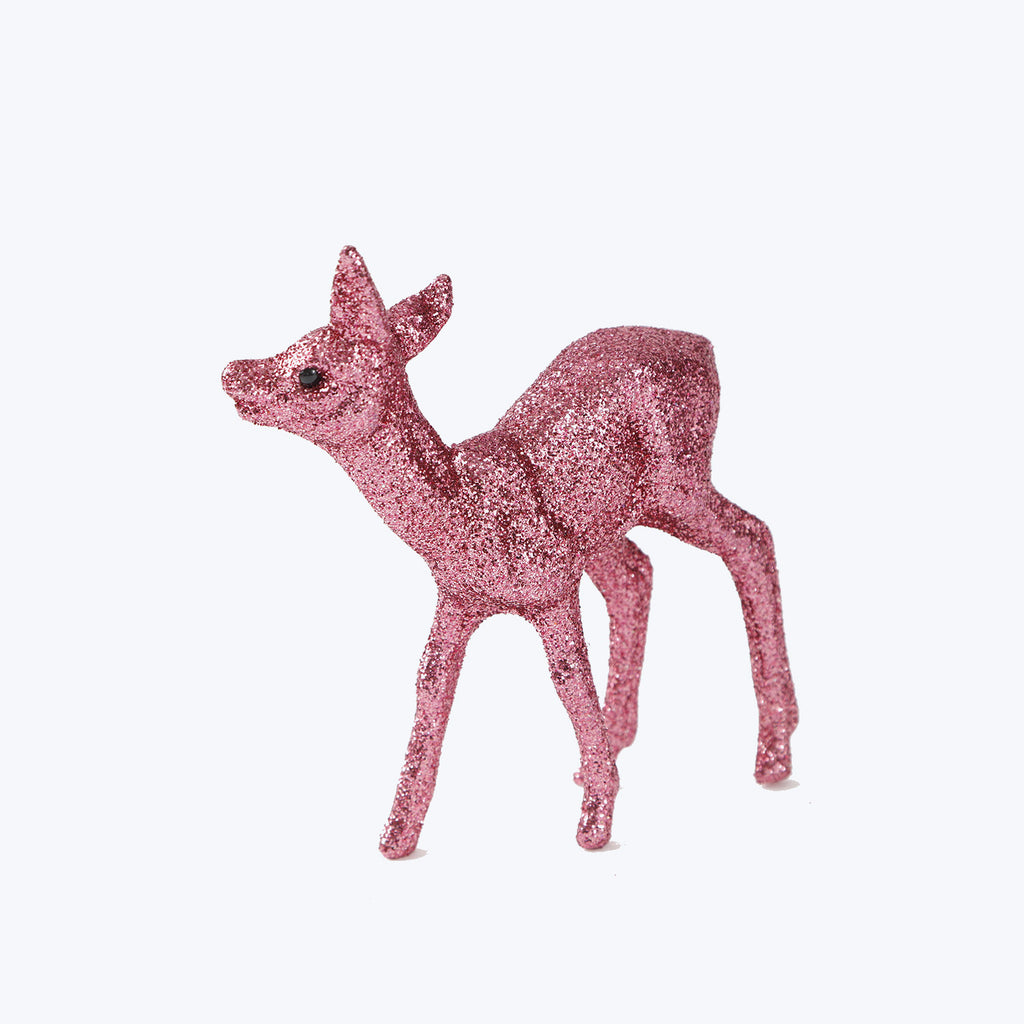 Sparkly deer figurine coated in pink glitter stands upright decoratively.