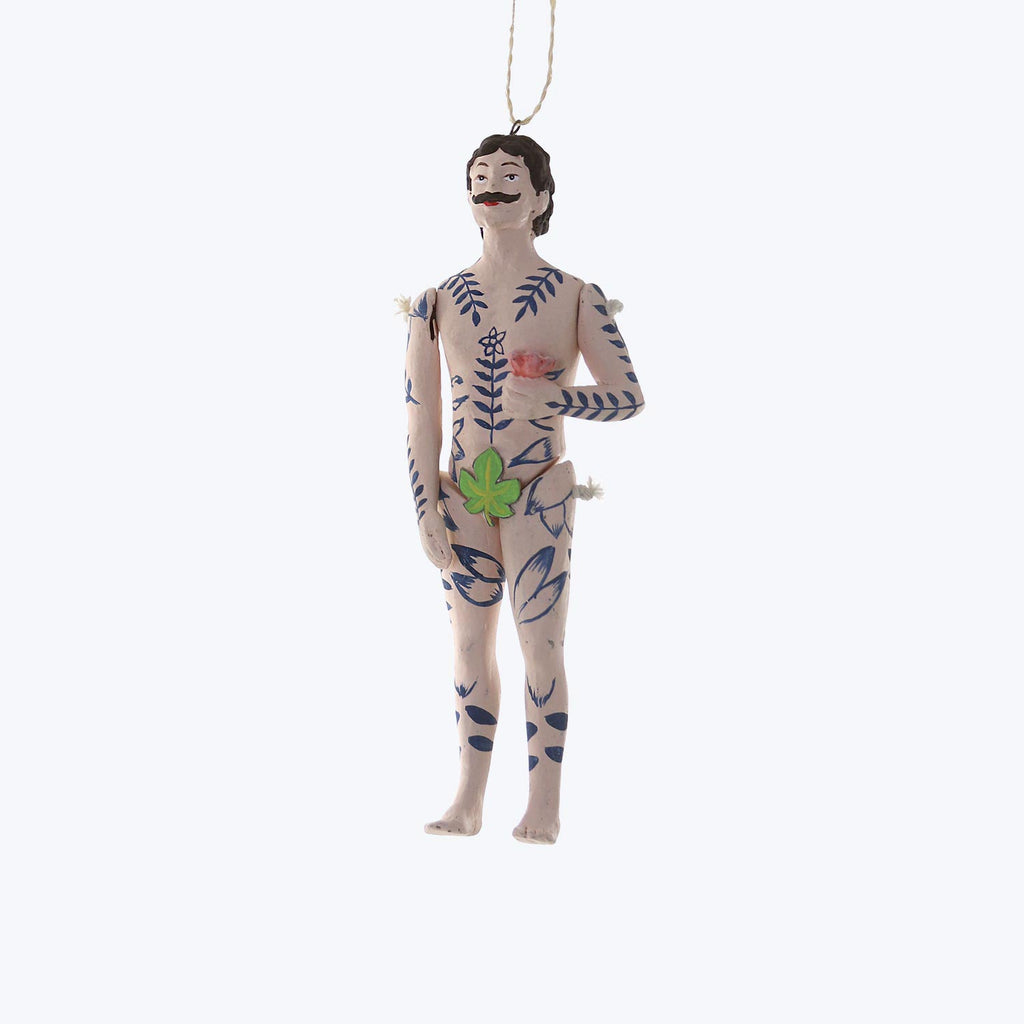 Handmade ornament of humanoid figure with floral tattoo design, suspended.