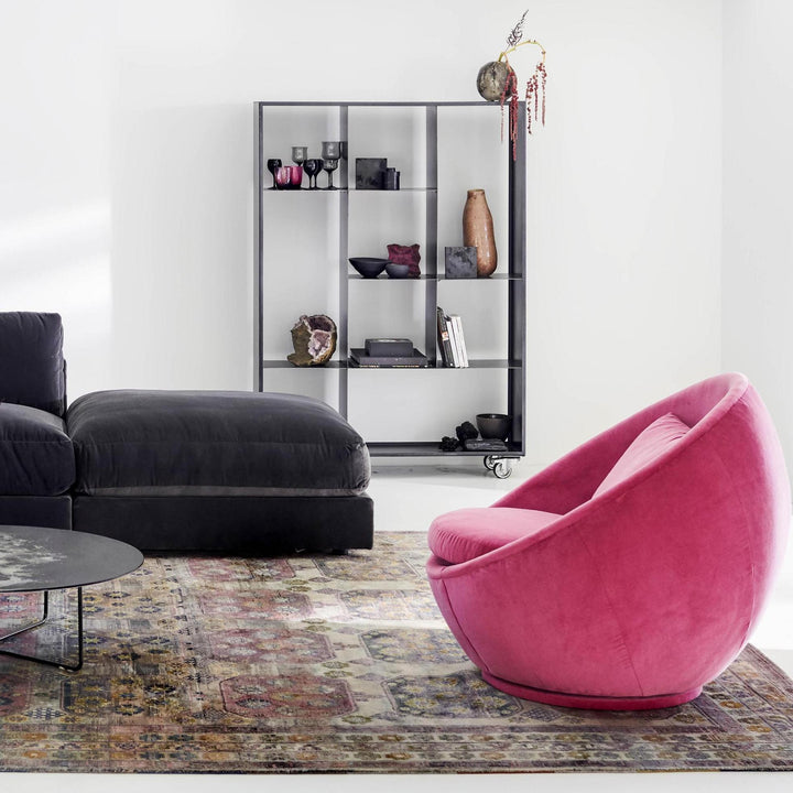 Minimalist living room with cozy seating, unique armchair, and sleek bookshelf