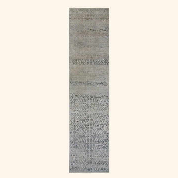 Long rectangular area rug with fading floral design in neutrals.