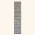 Long rectangular area rug with fading floral design in neutrals.