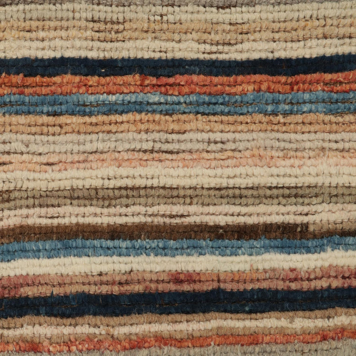 Close-up of handmade woven rug with earthy tones and stripes
