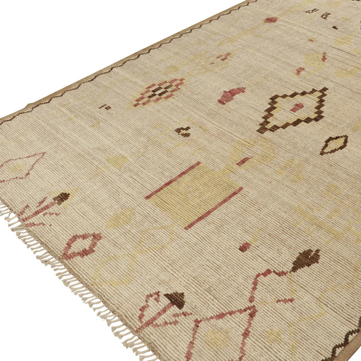 Handcrafted beige area rug with eclectic abstract pattern and fringe.