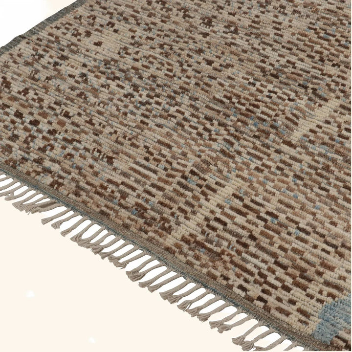 Close-up of plush woven rug with patterned design and fringe.