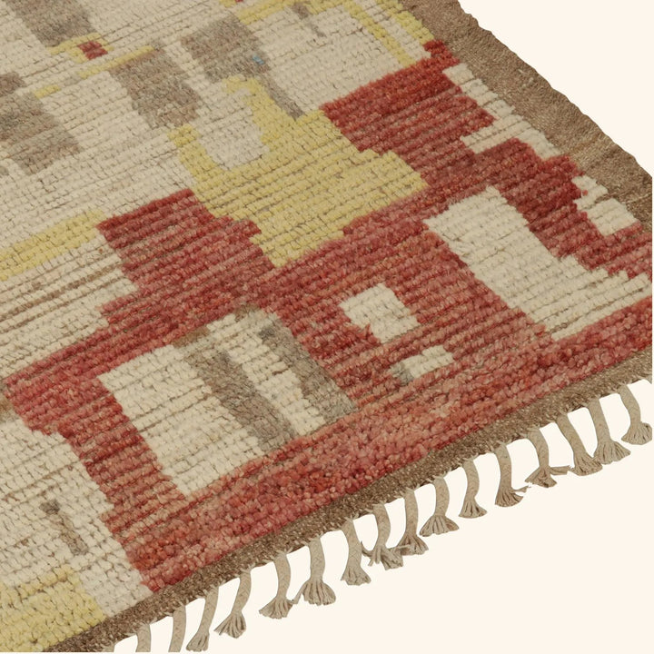 Close-up of colorful geometric patterned woven rug with fringe detail.