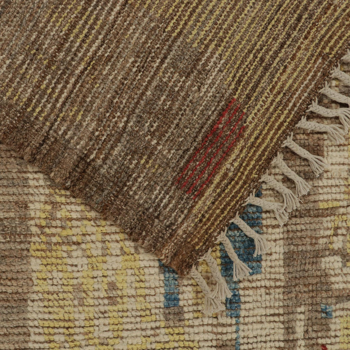 Close-up of hand-woven textile with earthy tones and fringe.