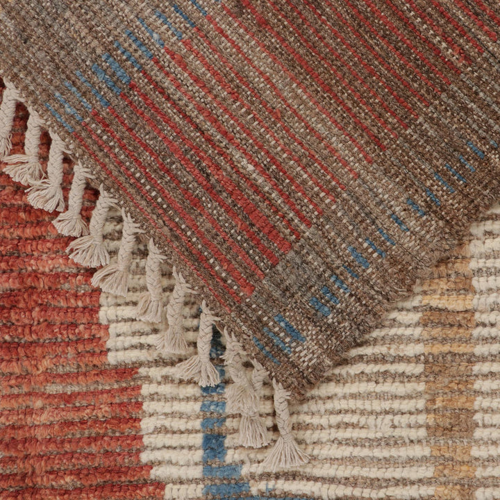Close-up of traditional handwoven textile with geometric patterns and fringe