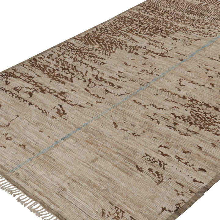 Modern beige rug with abstract brown patterns and blue accent.