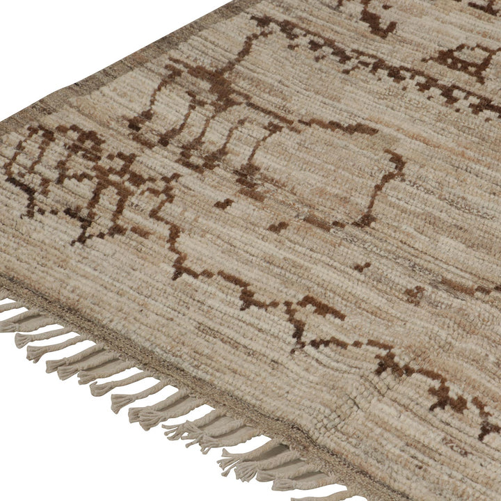 Elegant cream woven rug with tribal pattern and fringe tassels.