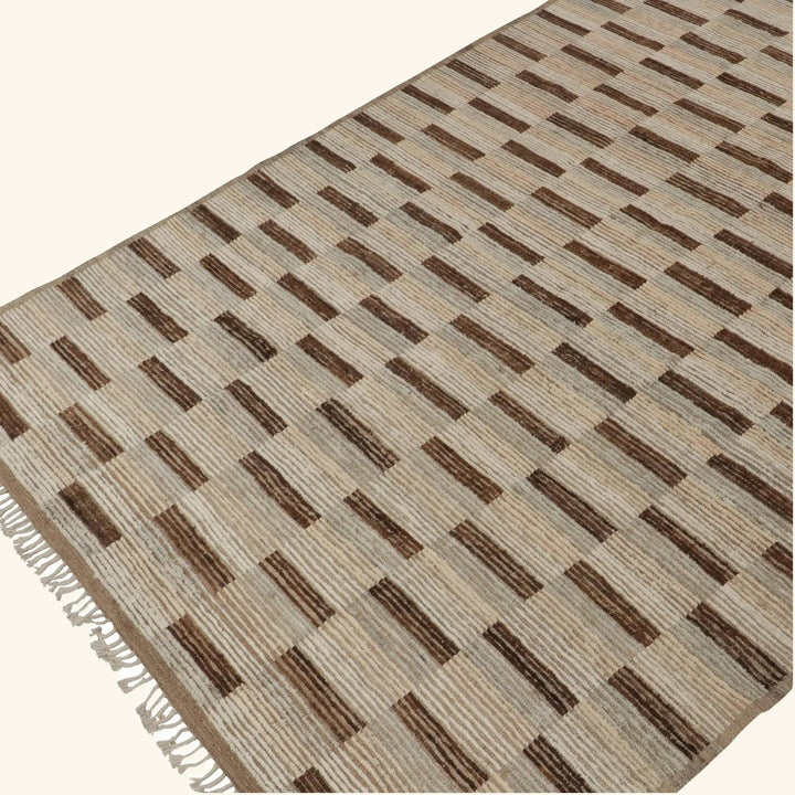 Contemporary geometric rug in brown and beige with fringe details.