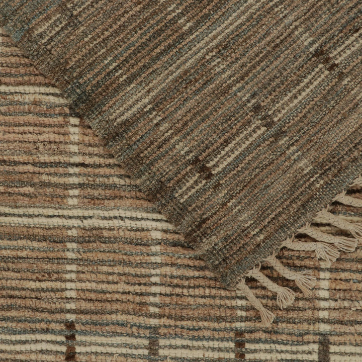 Close-up of textured fabric with striped pattern and fringe detail.