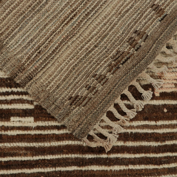 Richly textured striped fabric with fringed edge in earth tones.