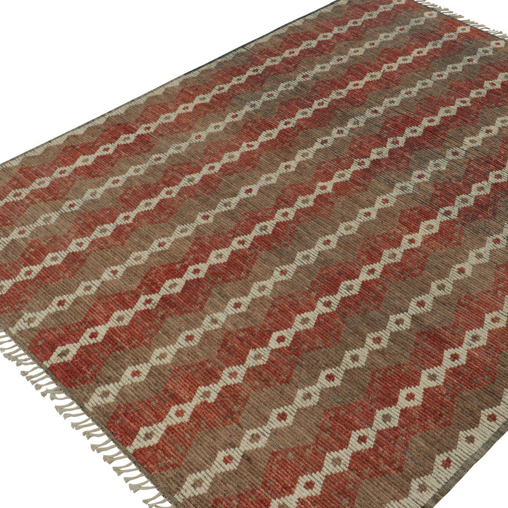 Symmetrical geometric pattern rug with fringe in warm color tones.
