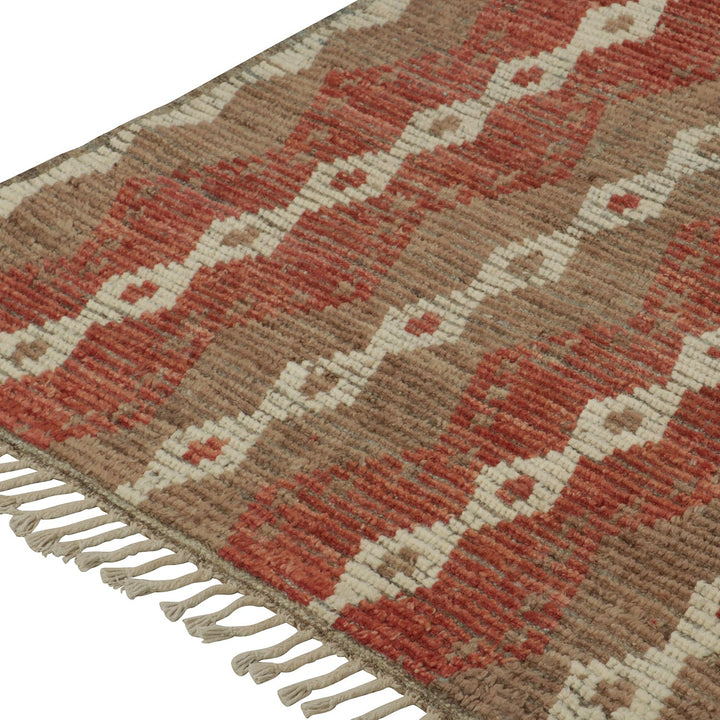 Handwoven rug with geometric patterns in earthy tones and fringe.