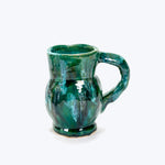 Hand-crafted ceramic mug with green, blue, and white variegated glaze.